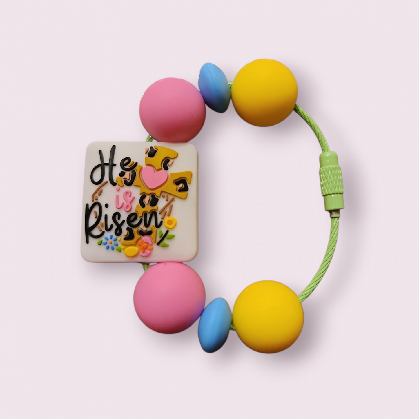 Colorful beaded bracelet with 'He is Risen' charm, pink, yellow, blue beads, green cord