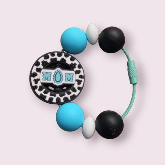 Blue, black, and white silicone teething bracelet with 'MOM' charm and leopard print design