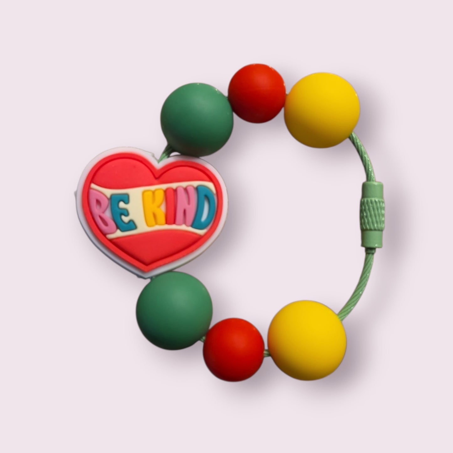 Colorful beaded bracelet with heart charm saying 'BE KIND', featuring green, red, and yellow beads on a green cord.