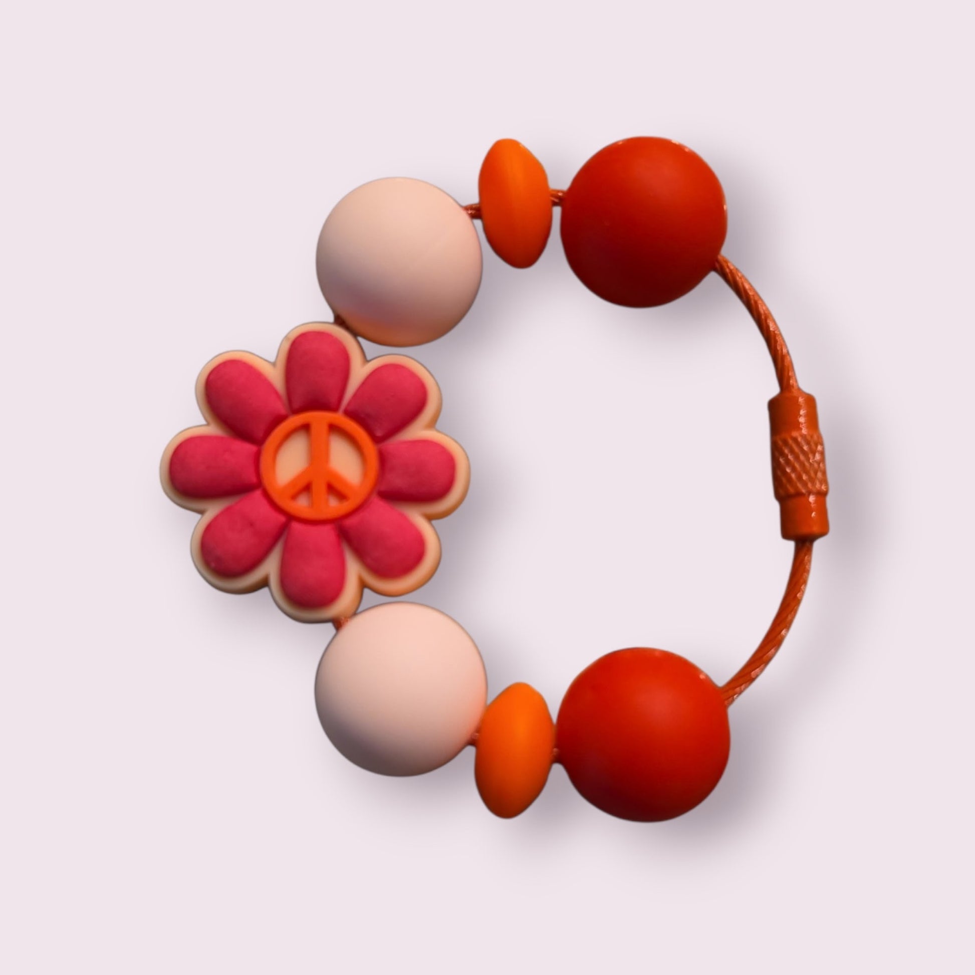 Colorful beaded bracelet with peace sign flower charm, orange cord, and round beads in pink, orange, and red tones